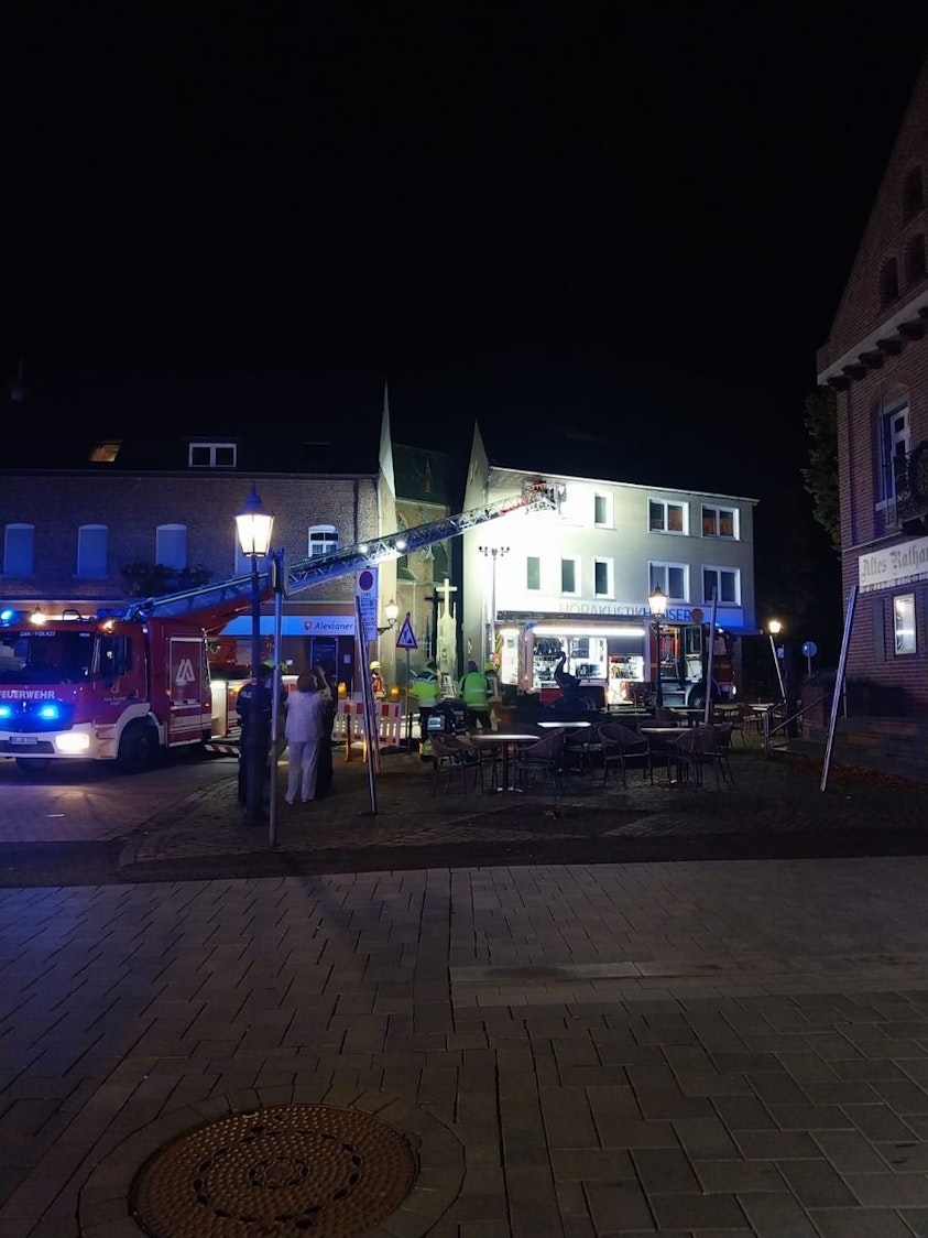 Ein Feuerwehrmann auf einer Drehleiter vor einem Haus in Gangelt.