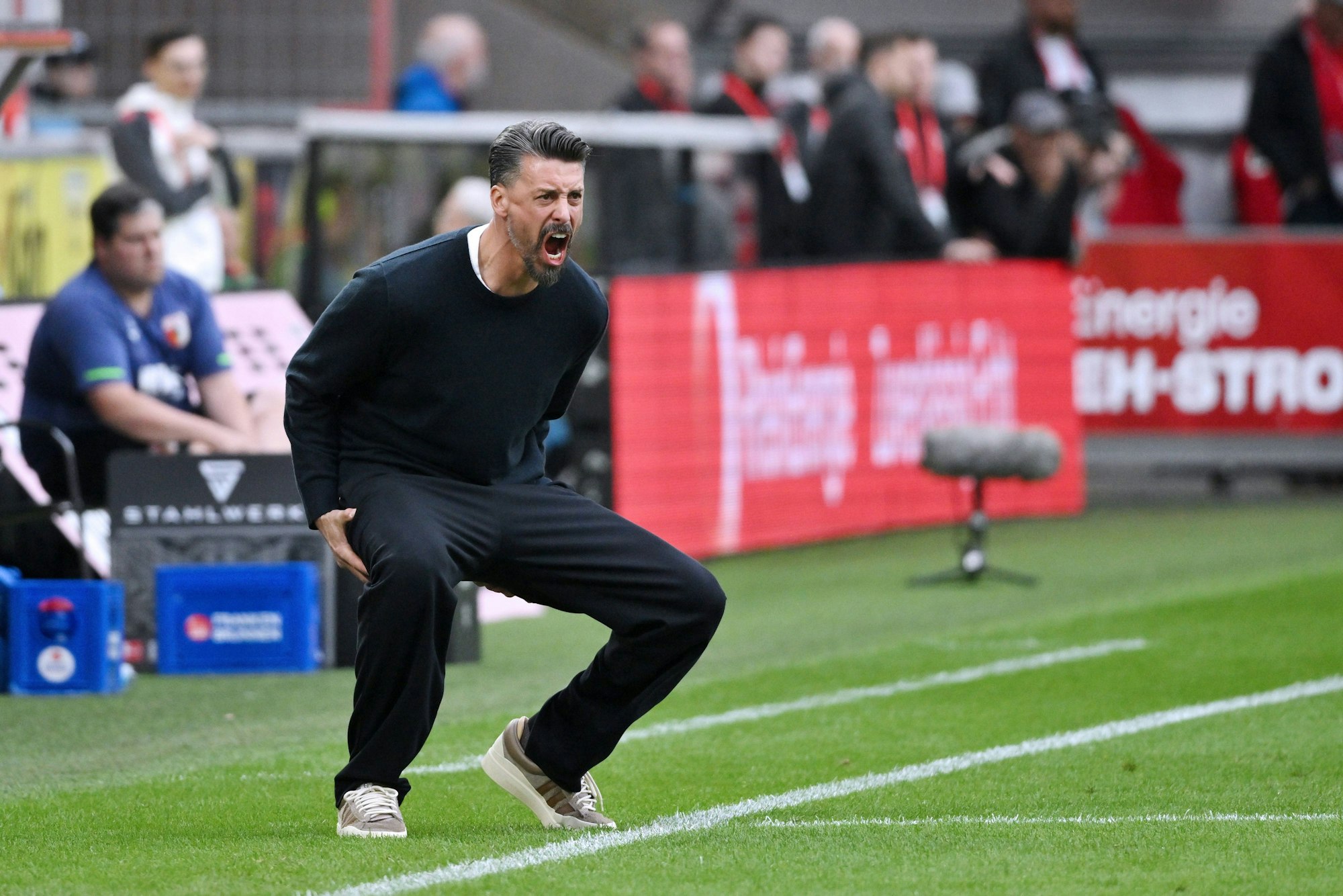 Sandro Wagner schreit an der Seiteinlinie, geht dabei in die Hocke.