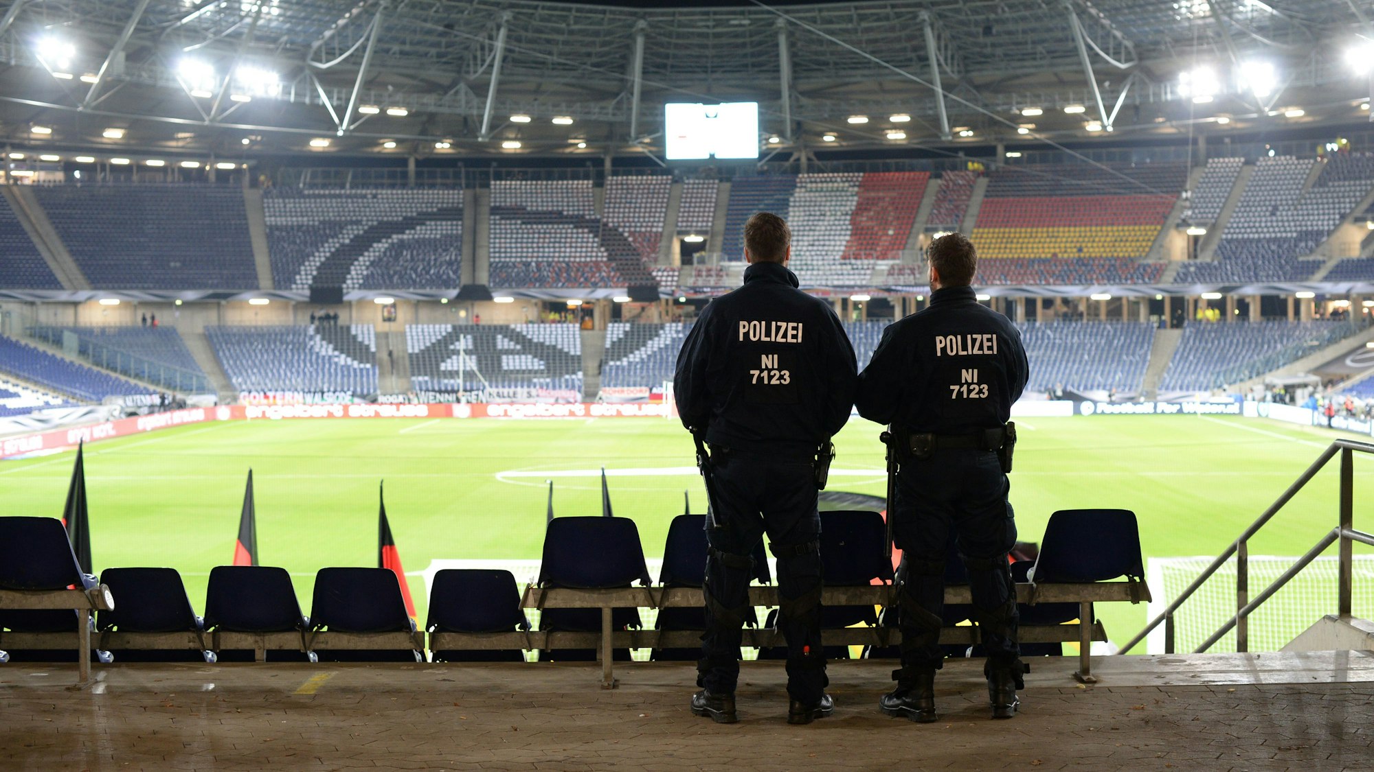 Zwei Polizisten stehen auf der Tribüne des Stadions von Hannover.