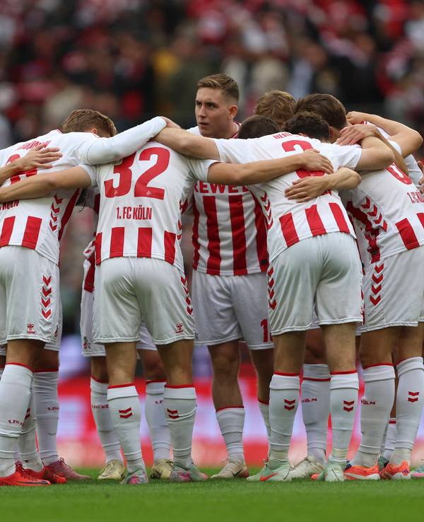 Die Spieler des 1. FC Köln bilden vor dem Anpfiff einen Kreis.