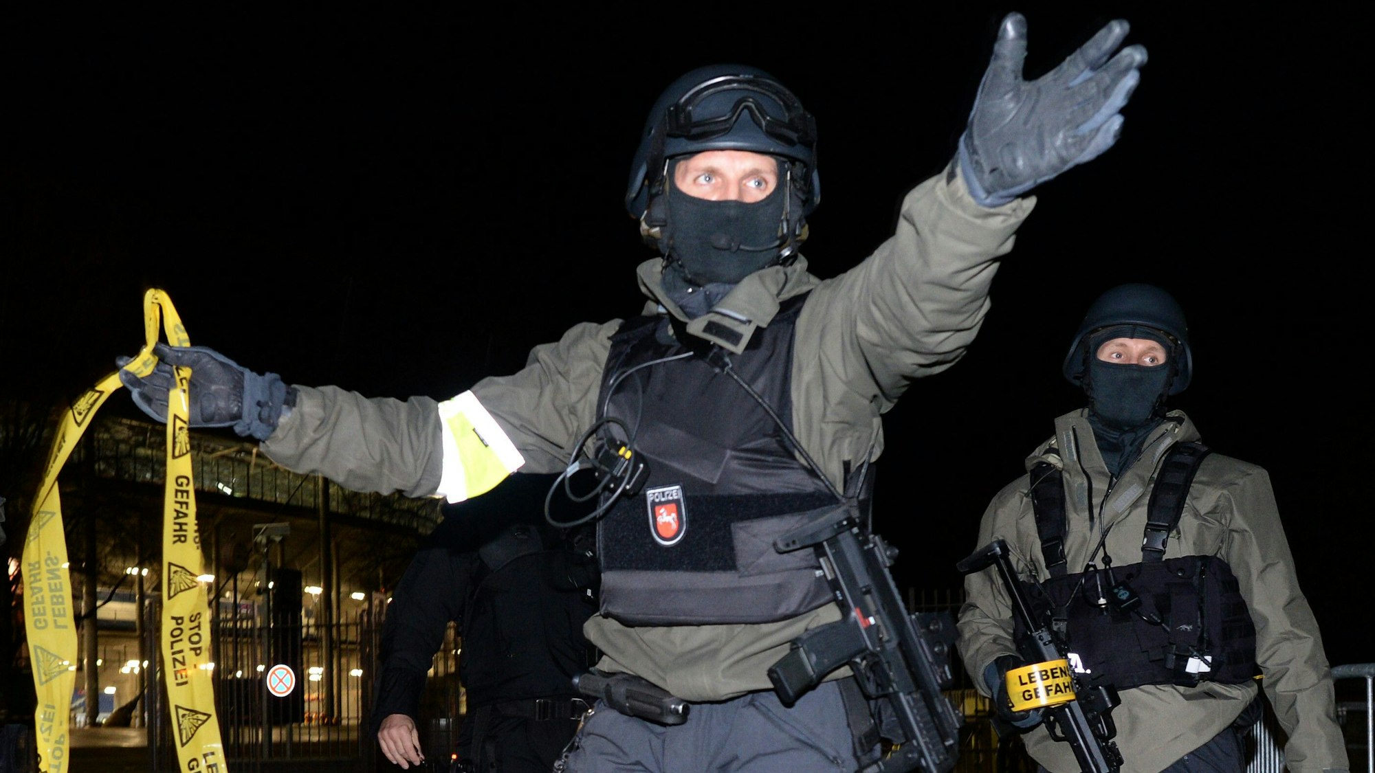 Polizisten mit Sturmgewehren stehen vor dem geschlossenen Stadion und sperren den Bereich ab.