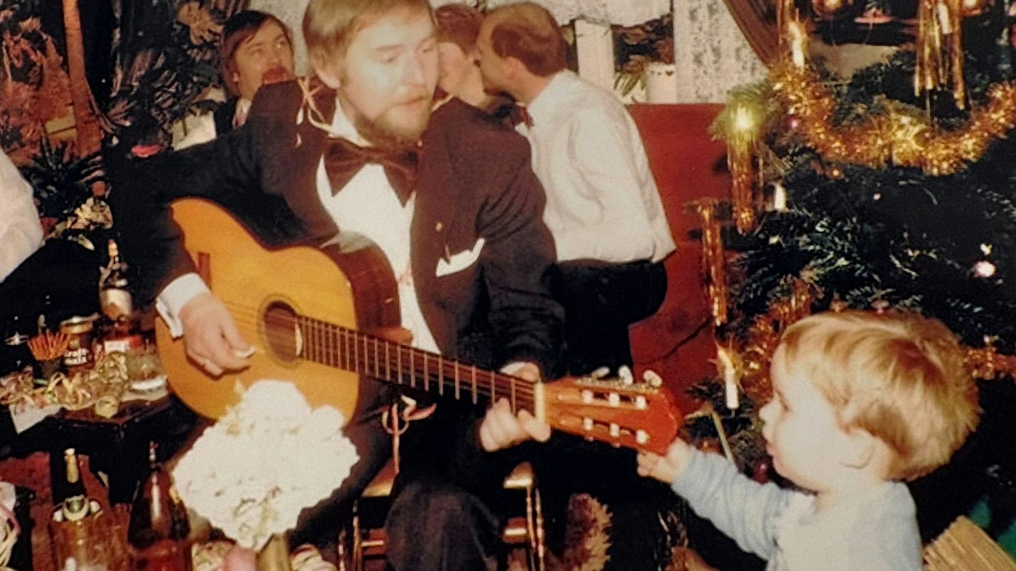 Günter Heuser singt an der Gitarre Lieder für seinen Sohn Björn.