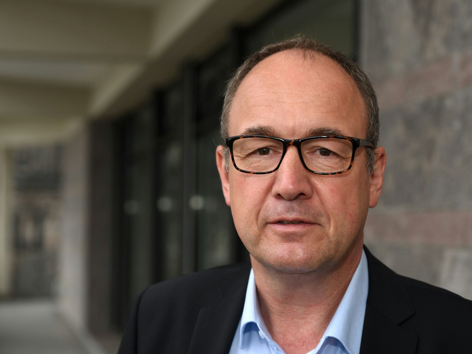 Rainer Tüschenbönner, ein Mann mit hoher Stirn und Brille