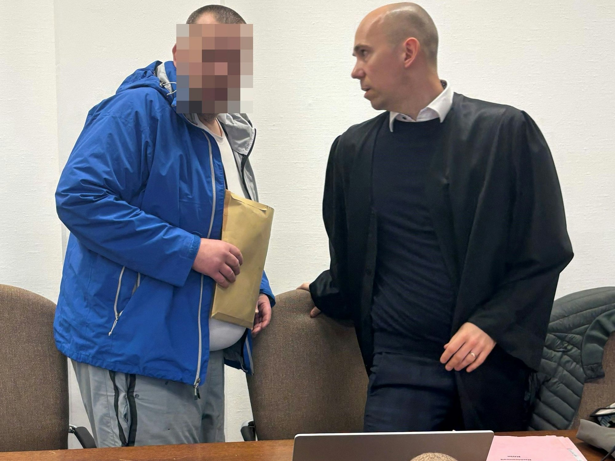 Ein Angeklagter spricht mit seinem Anwalt.