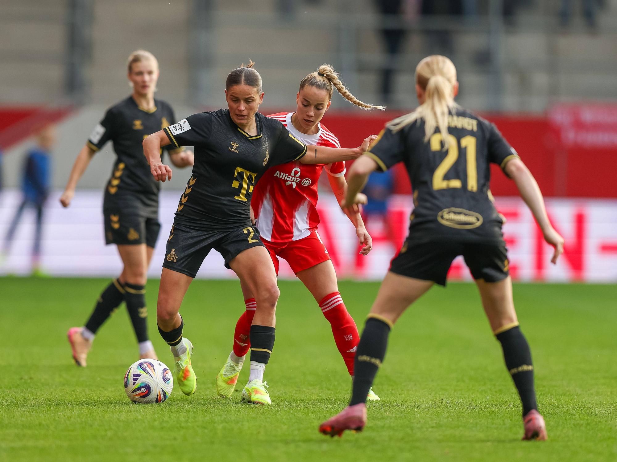Giulia Gwinn (M.) und Laura Feiersinger (l.) im Zweikampf um den Ball.