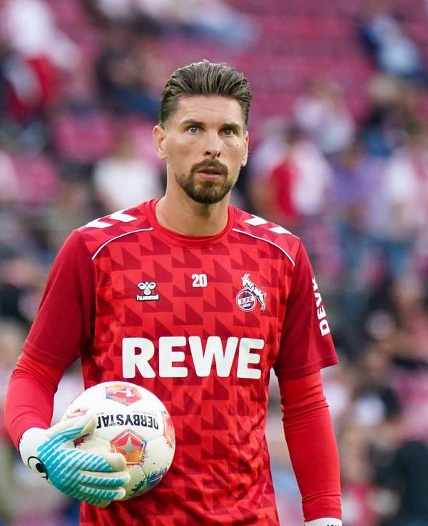 Ron-Robert Zieler hat einen Ball in seiner Hand und guckt in die Ferne.