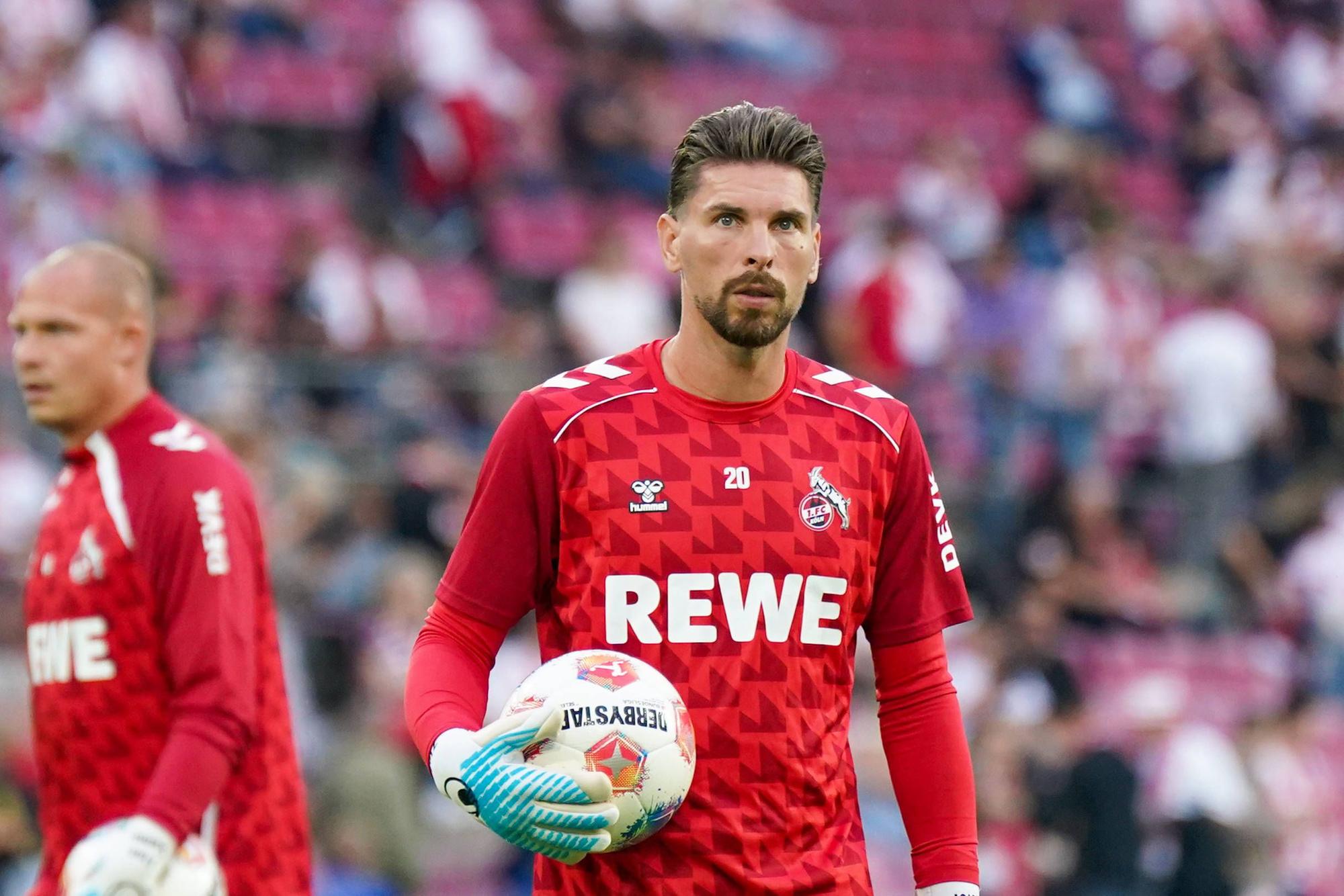 Ron-Robert Zieler hat einen Ball in seiner Hand und guckt in die Ferne.