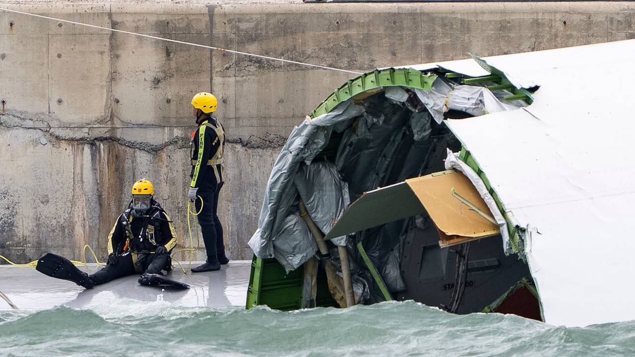 Ein Taucher bereitet sich auf die Inspektion des Frachtflugzeugs vor, das auf dem Flughafen in Hongkong von der Landebahn abgekommen ist und über die Piste hinaus ins Meer schlitterte.