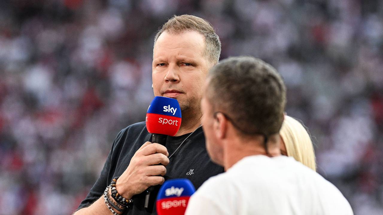 Wolff Fuss hält ein Sky-Mikrofon vor seinen Mund und guckt streng.