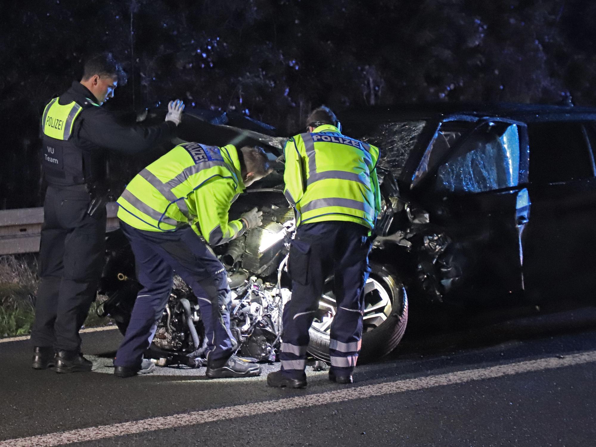 Einsatzkräfte der Polizei arbeiten an einem verunfallten Fahrzeug. Durch einen Geisterfahrer war es auf der A3 zu einem tödlichen Unfall gekommen.