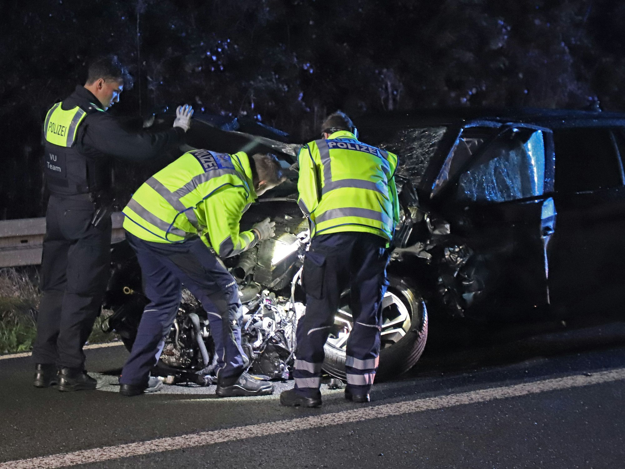 Einsatzkräfte der Polizei arbeiten an einem verunfallten Fahrzeug. Durch einen Geisterfahrer war es auf der A3 zu einem tödlichen Unfall gekommen.