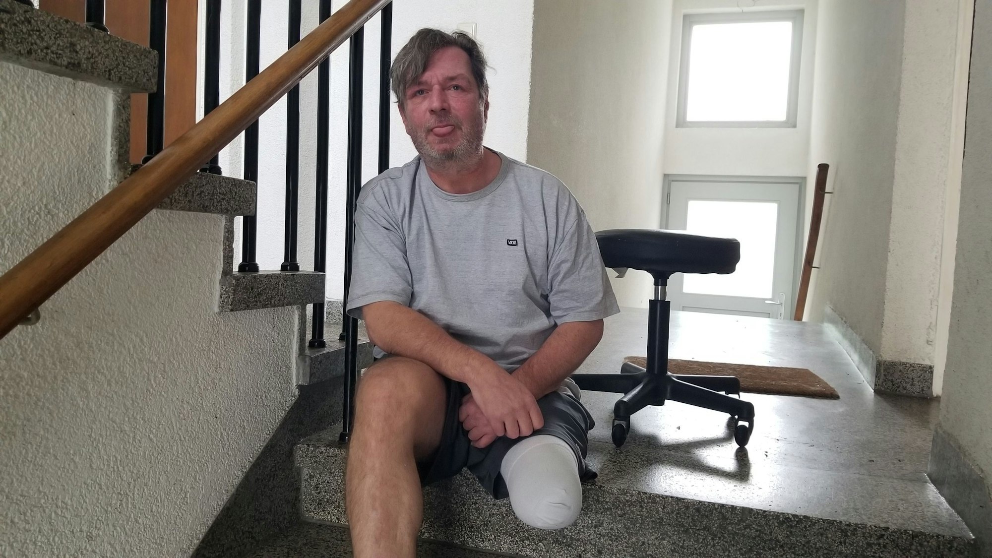 Thomas Pieper sitzt auf der Treppe vor seiner Wohnung. Ohne Hilfe kommt er hier nicht mehr runter.
