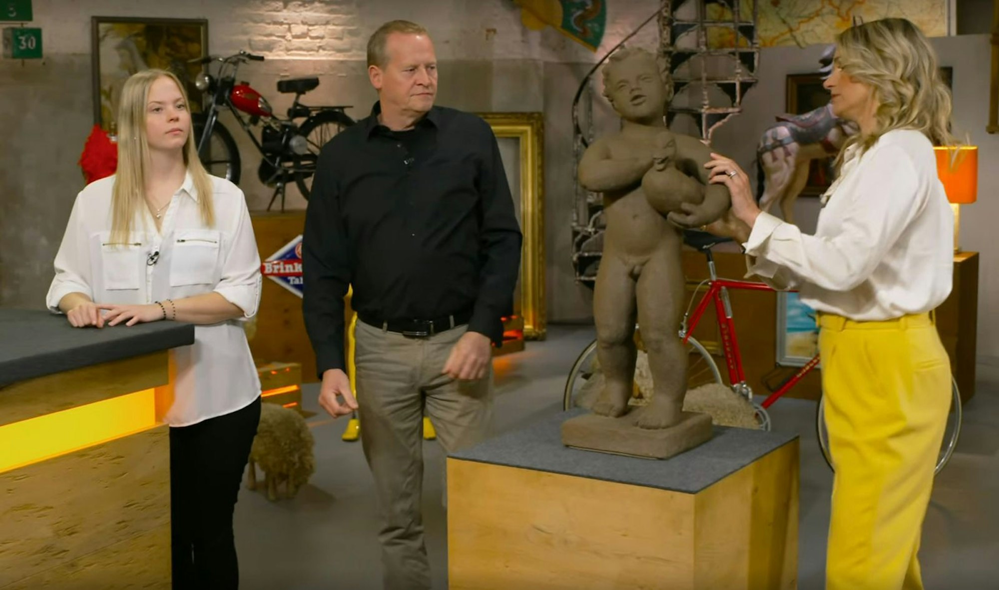 Rudi Schulze fand bei Gartenarbeiten bei einer Bekannten diese Figur. Weil der als Volleyballnetz-Halter herhalten musste, will er ihn gemeinsam mit Tochter Lisa „retten“. Dr. Bianca Berding taxiert den blanken Terrakotta-Buben mit Ente unter dem Arm auf ein Alter von rund 75 Jahren. Die Brunnenfigur wurde von der Keramikmanufaktur Karlsruhe gefertigt. (Bild: ZDF)