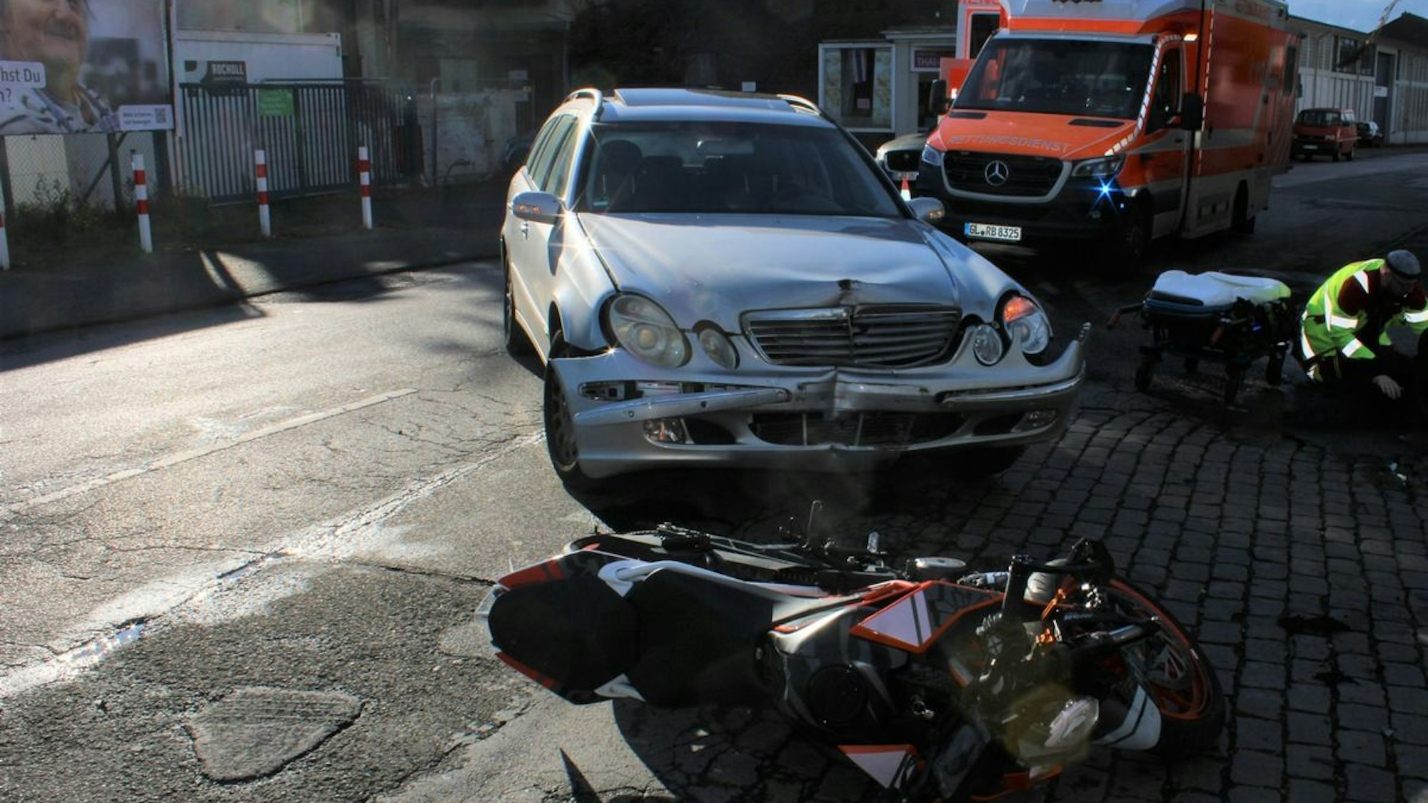 Ein Motorrad und ein Auto nach einem Unfall auf einer Straße.