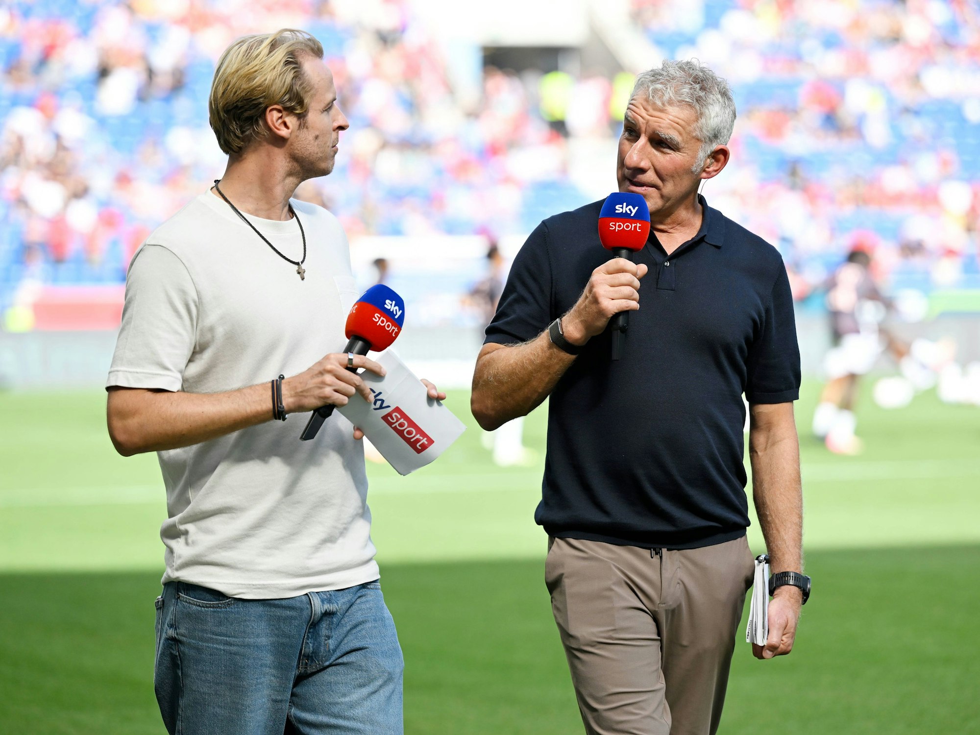 Mirko Slomka wird von Yannick Erkenbrecher interviewt und spricht in ein Mikrofon.