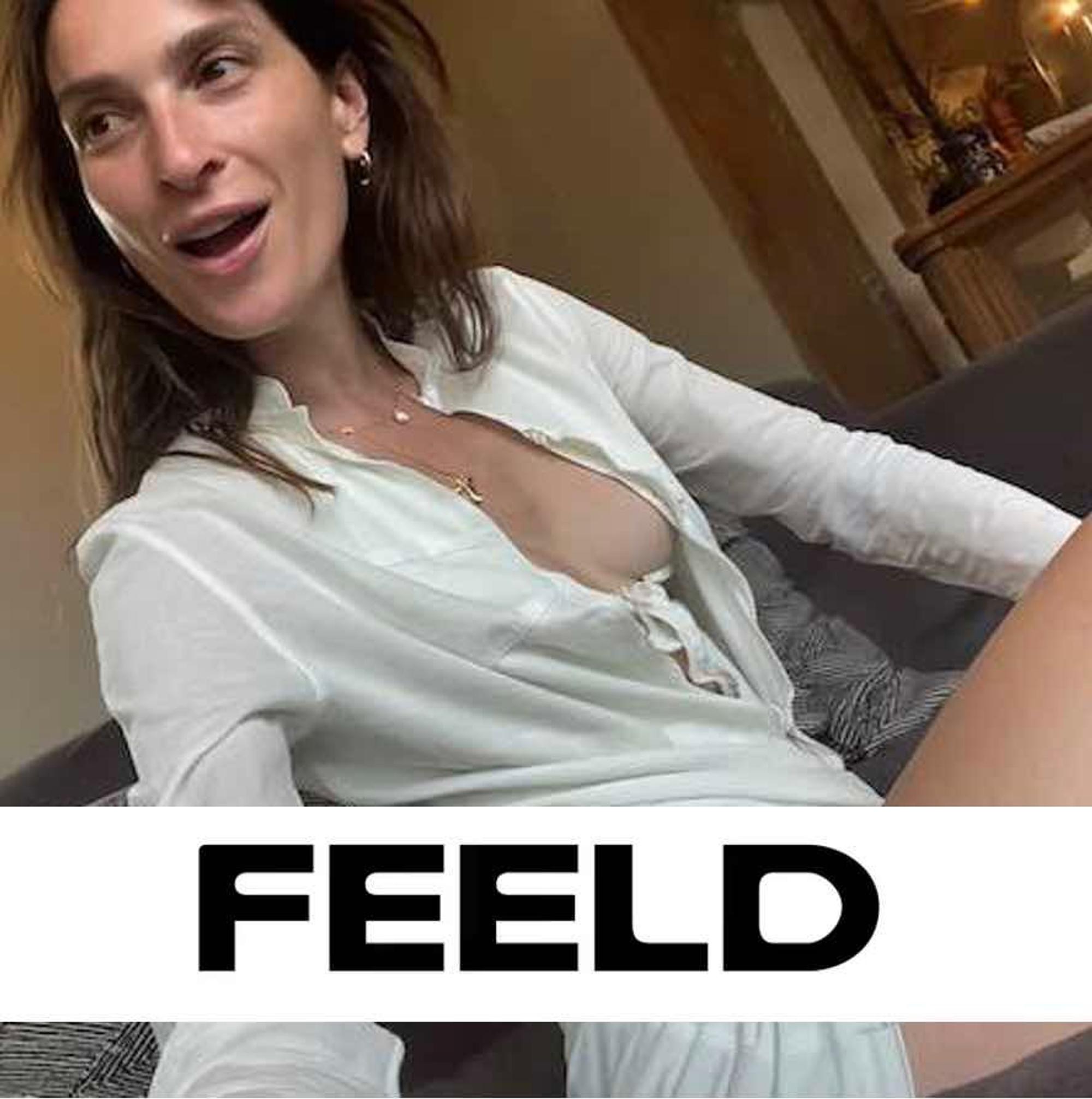 Brünette Frau mit weißer Bluse schießt ein Selfie.