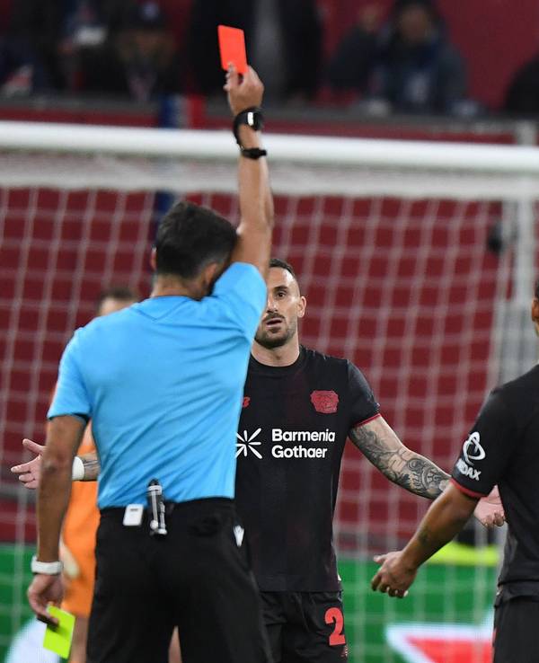 Robert Andrich bekommt vom Schiedsrichter die Rote Karte gezeigt und geht mit gesenktem Kopf weg.