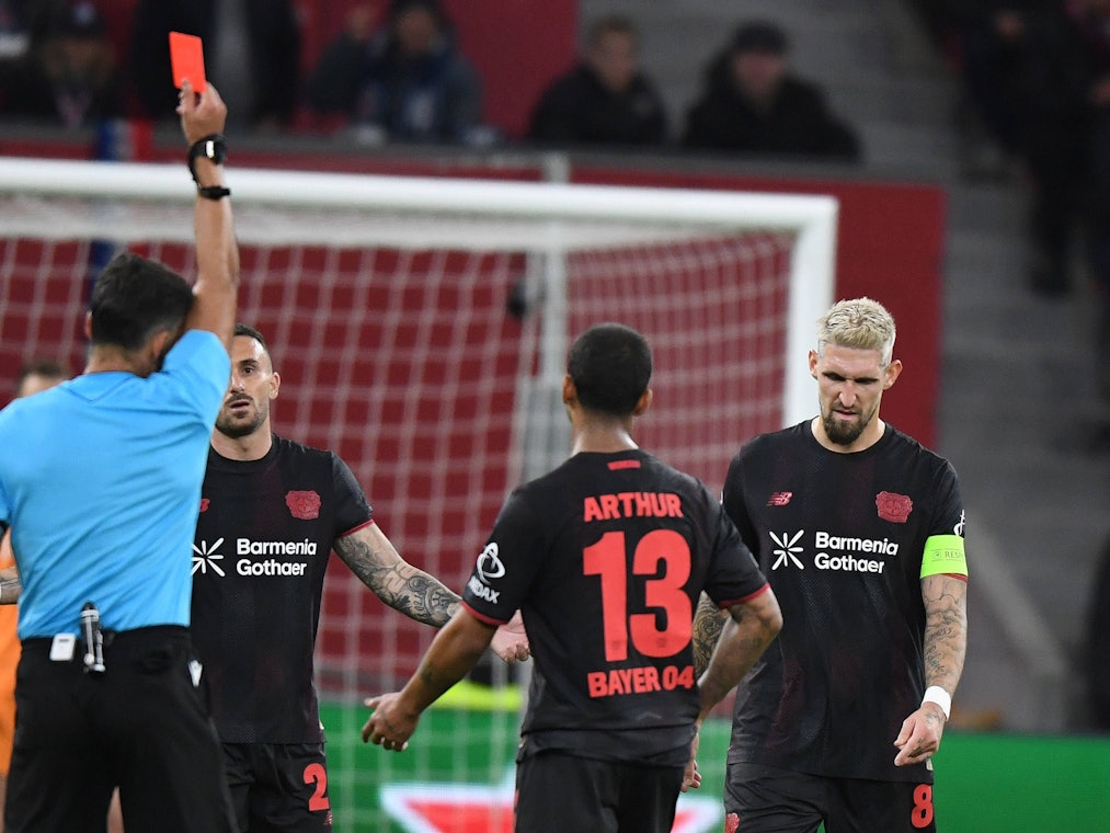 Robert Andrich bekommt vom Schiedsrichter die Rote Karte gezeigt und geht mit gesenktem Kopf weg.