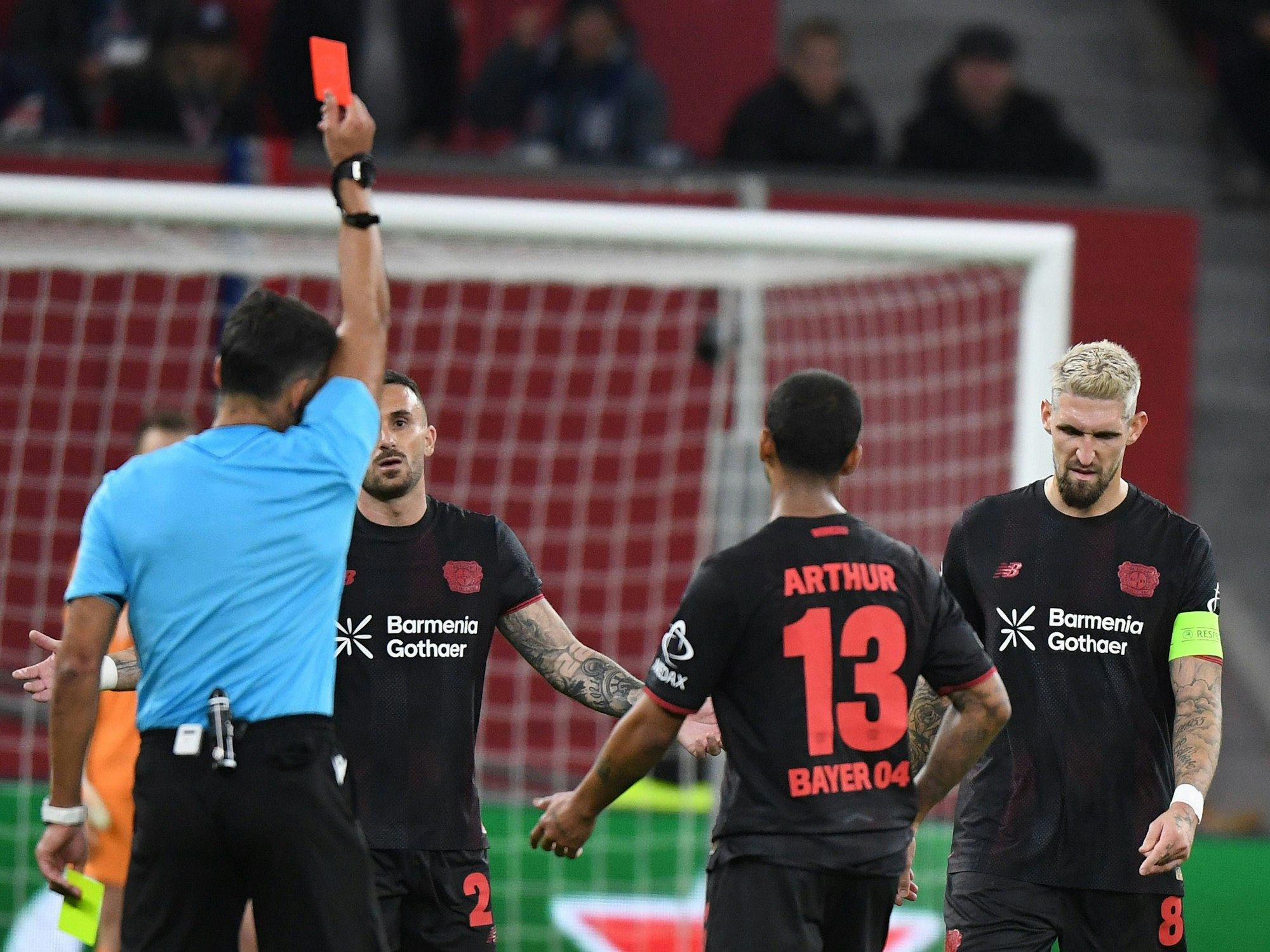 Robert Andrich bekommt vom Schiedsrichter die Rote Karte gezeigt und geht mit gesenktem Kopf weg.