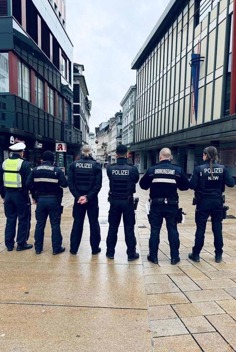 Ein Polizist steht neben einem E-Scooter (Symbolbild).