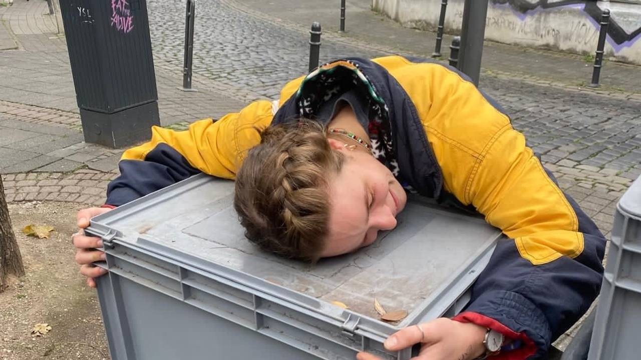 Eine Frau umarmt eine große Kiste, die auf einem Fahrrad steht.