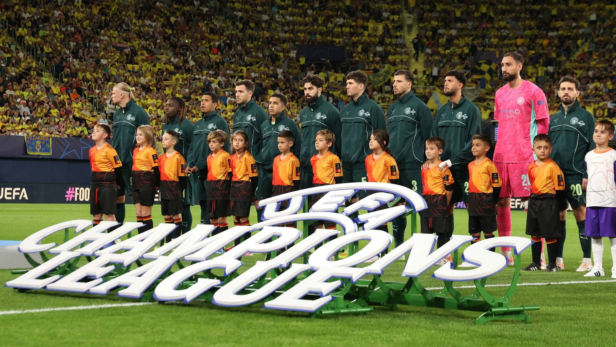 Die Spieler von Manchester City stehen vor dem Spiel nebeneinander auf dem Rasen, während die Champions-League-Hymne läuft.