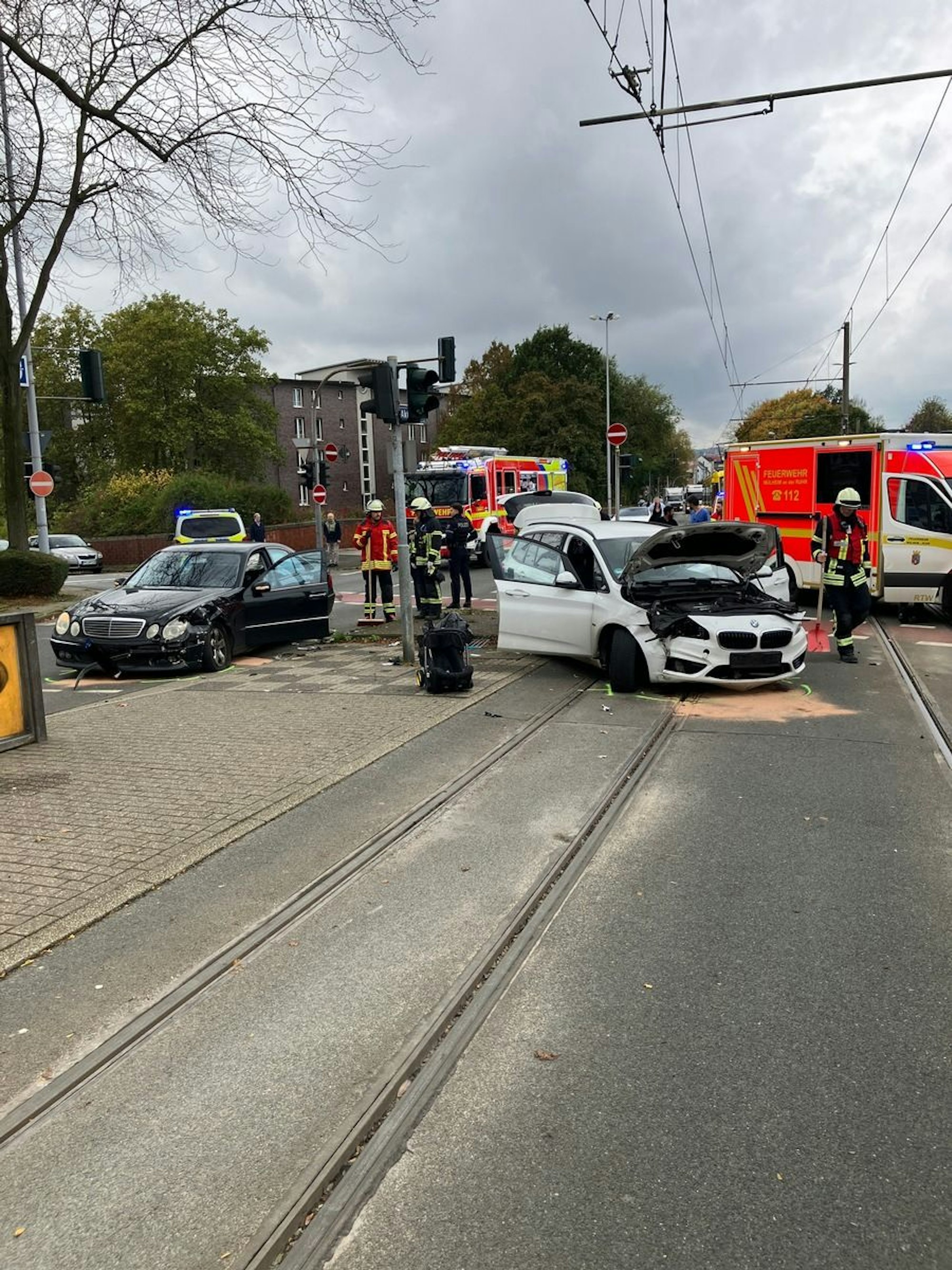 Zwei verunfallte Autos stehen auf einer Kreuzung. Im Hintergrund ein Fahrzeug der Feuerwehr.