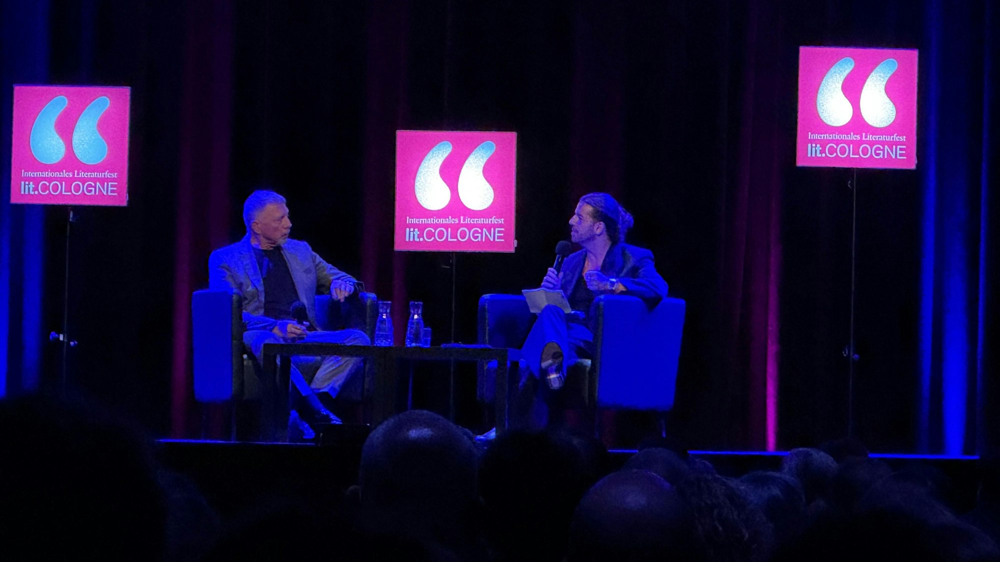 Boris Becker und Riccardo Basile im Theater am Tanzbrunnen bei der Lit.Cologne auf der Bühne.
