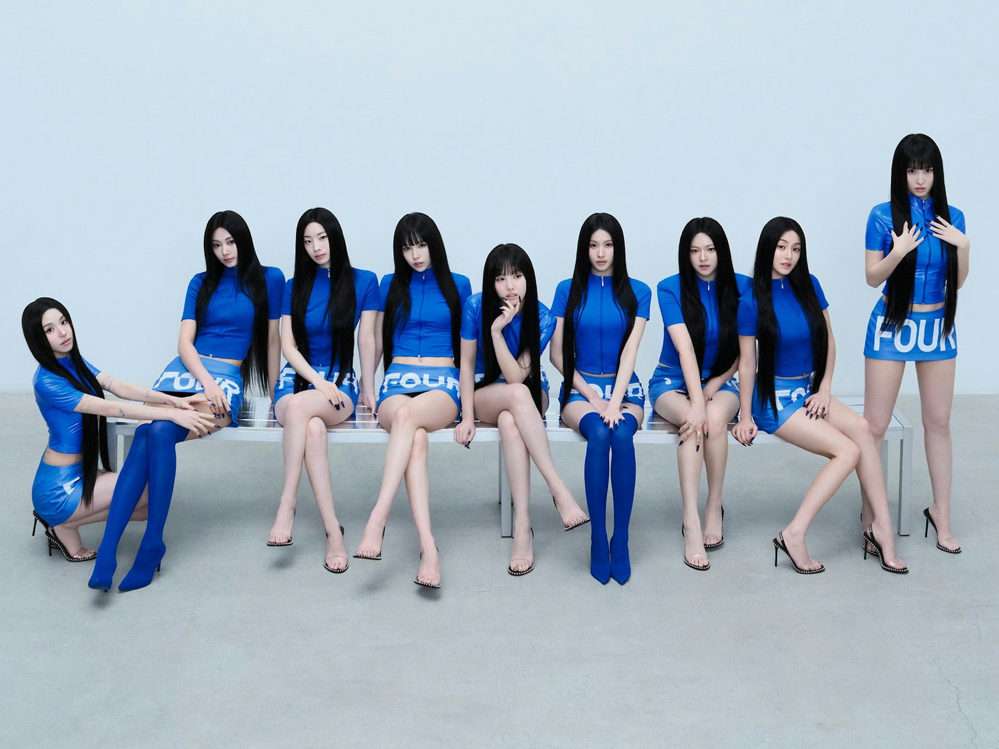 Die Band Twice sitzt auf einer Bank.