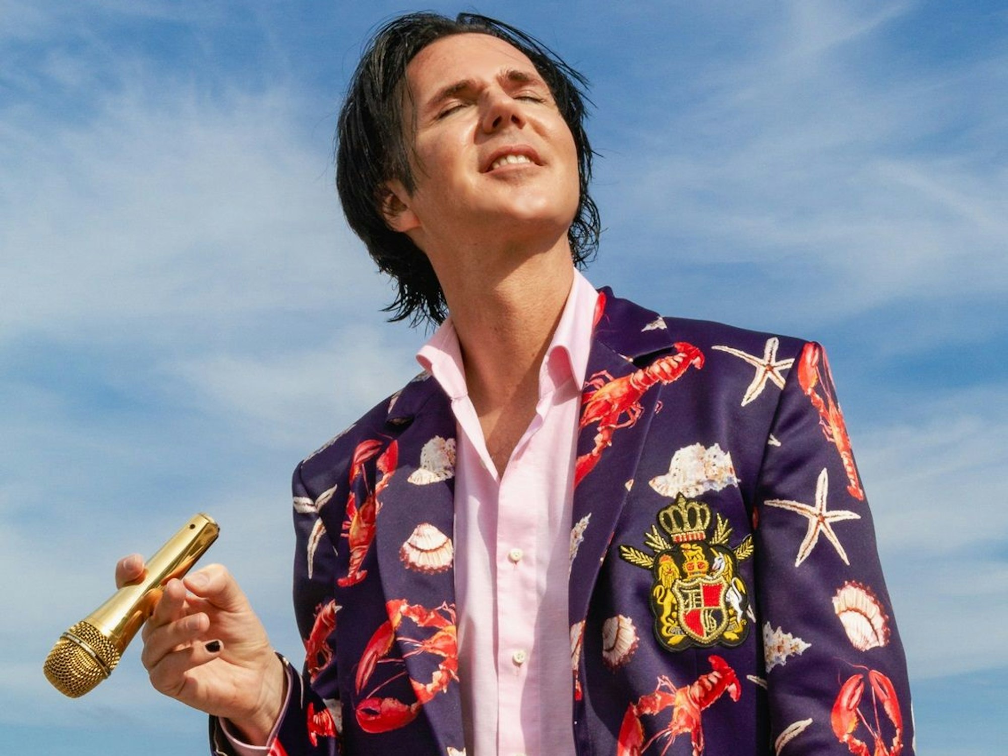 Der Musiker Alexander Marcus hält ein Mikro in der Hand.