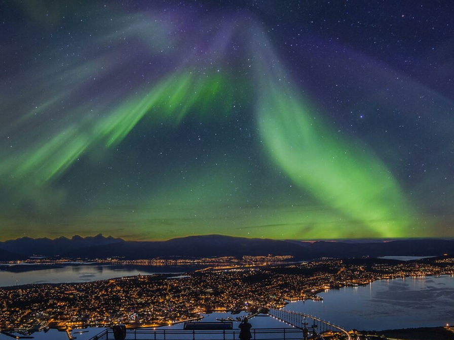 Das Bild zeigt die Polarlichter über der norwegischen Stadt Tromsø