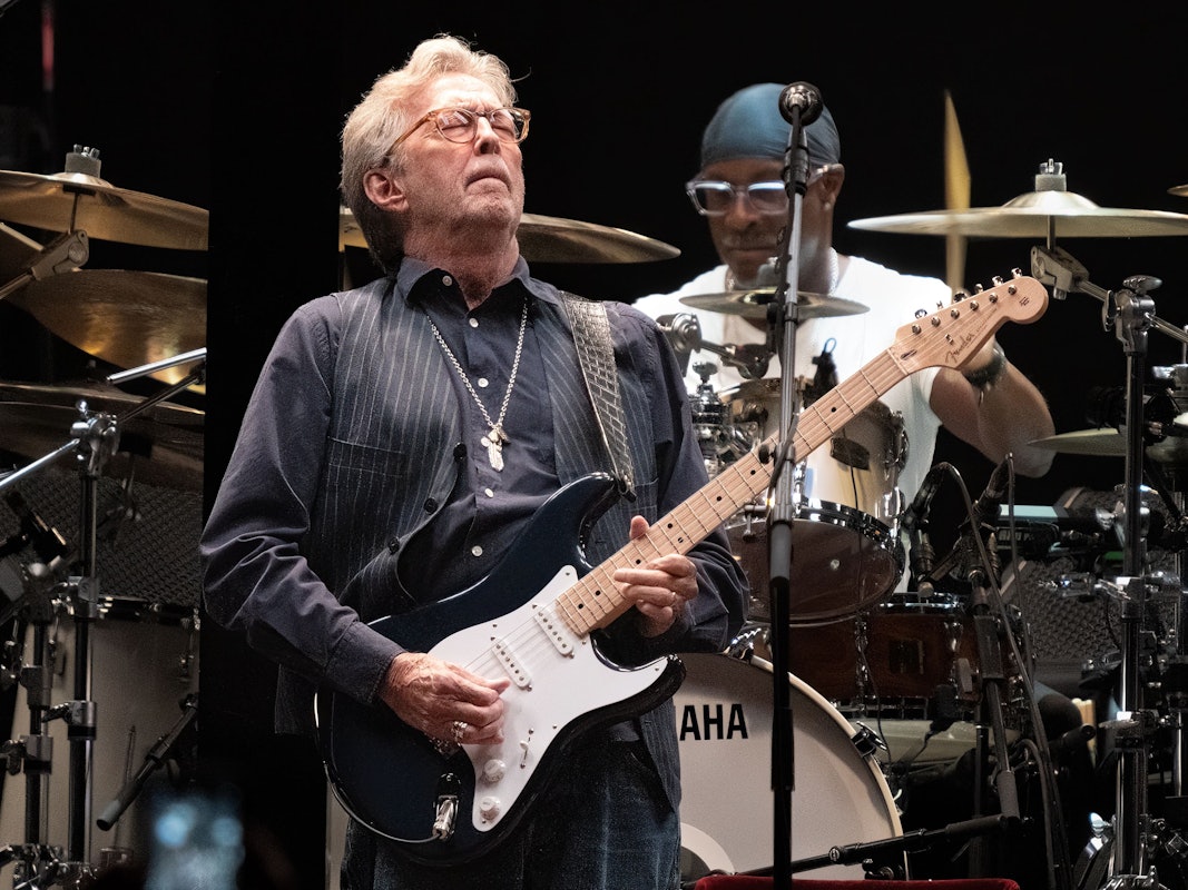 Eric Clapton spielt auf der Bühne Gitarre.