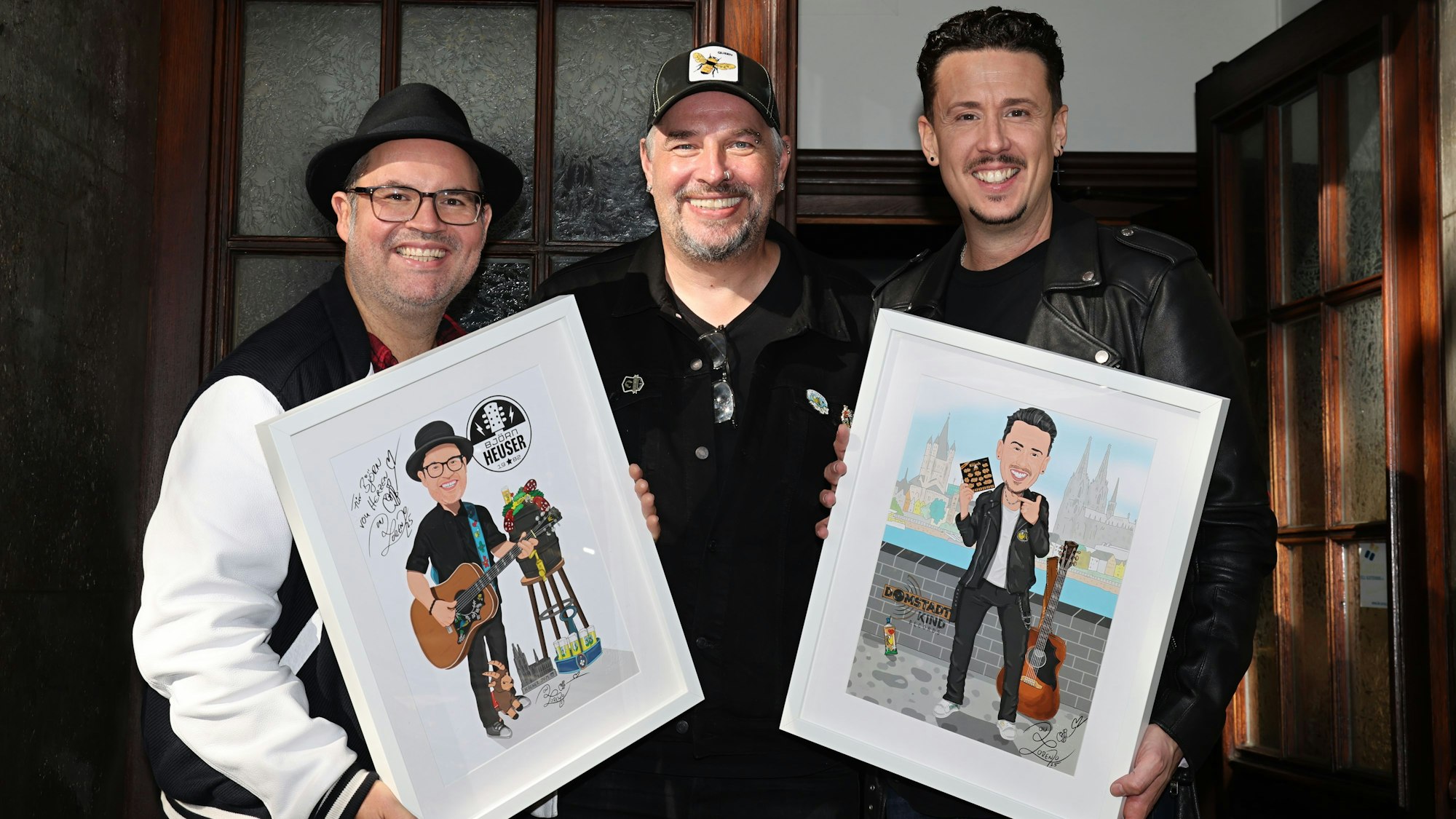 Der Künstler Don Lorenzo gibt Björn Heuser und Manuel Sauer Bilder.