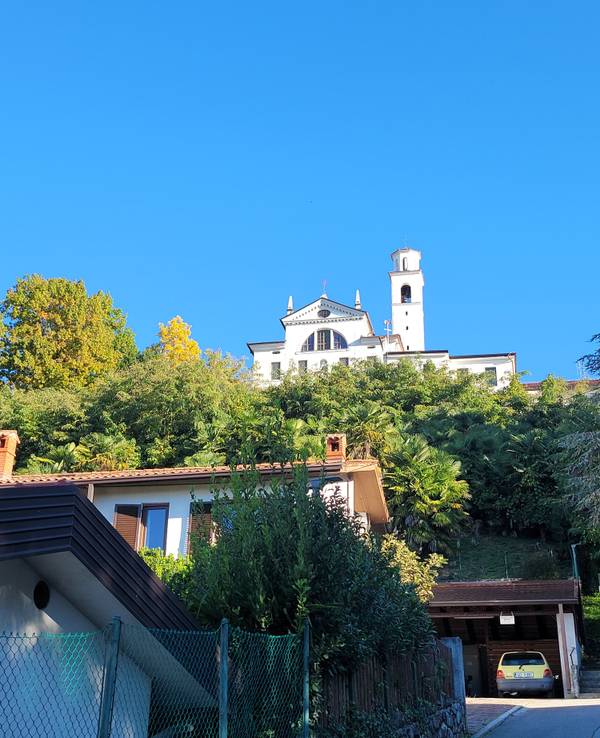 Eine Klosterkirche in strahlendem Weiß ragt in den blauen Himmel auf.