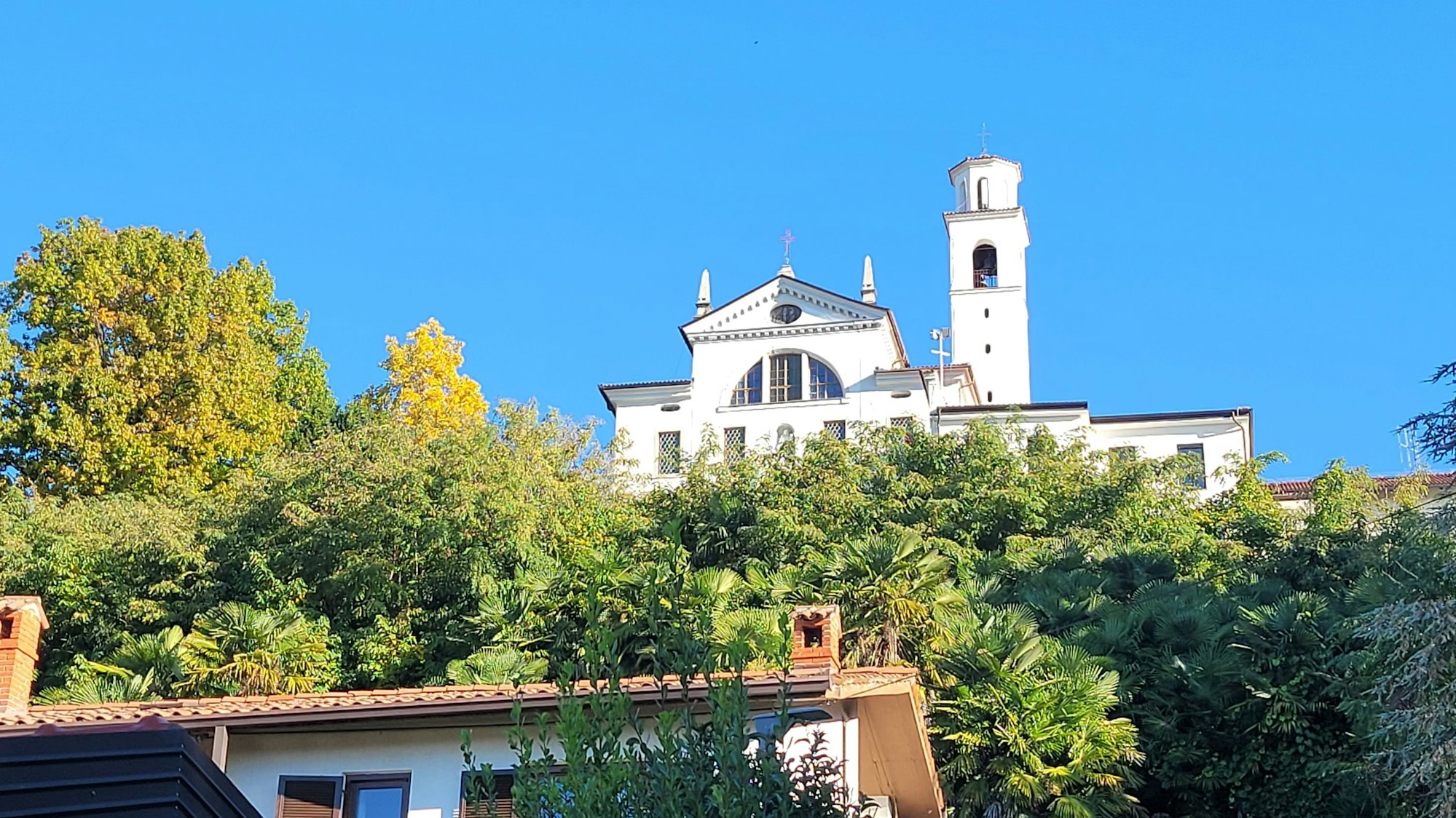 Eine Klosterkirche in strahlendem Weiß ragt in den blauen Himmel auf.