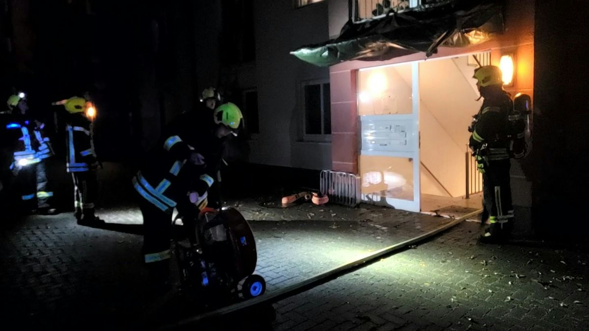 Ein Feuerwehrmann in voller Montur mit Atemschutzmaske geht durch eine verrauchte Wohnung.