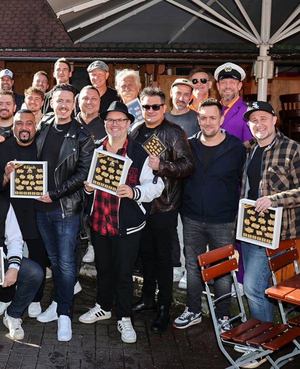 Viele Musiker halten Bilderrahmen von „Kölsch & Jot“ in der Hand.