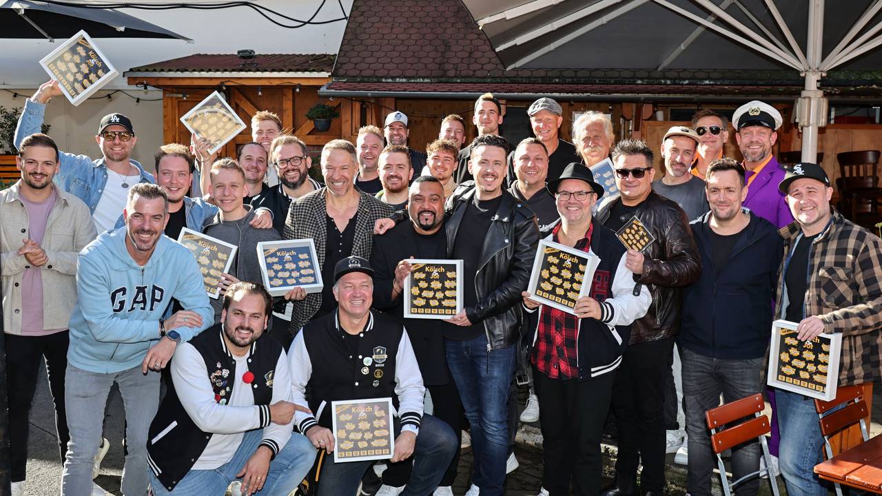 Viele Musiker halten Bilderrahmen von „Kölsch & Jot“ in der Hand.
