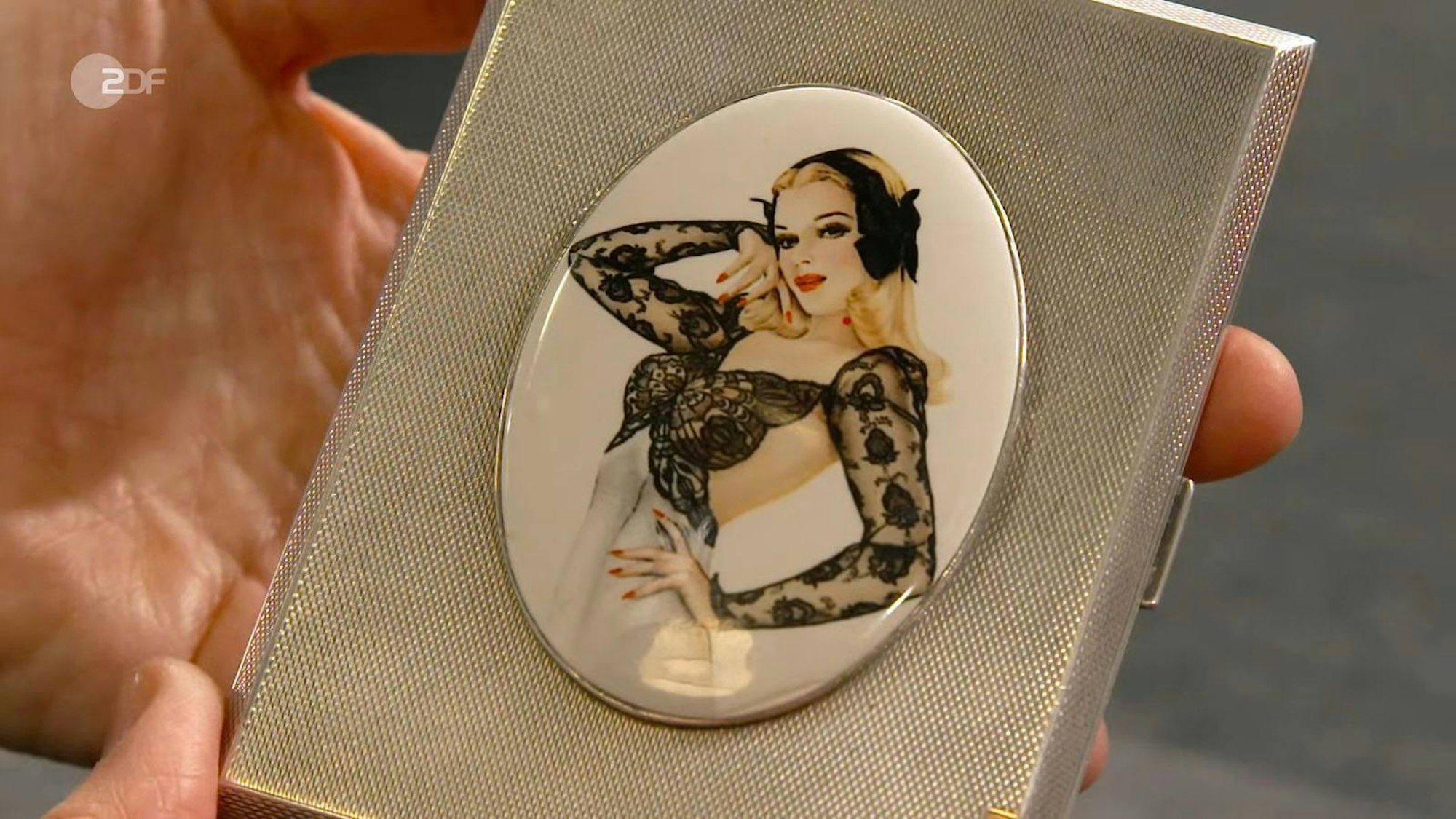 Das silberne Zigarettenetui aus dem Jahr 1947 mit einem Pin-up Girl aus Emaille sollte 300 bis 350 Euro bringen. Elke Velten zahlte 330 Euro.
 (Bild: ZDF)