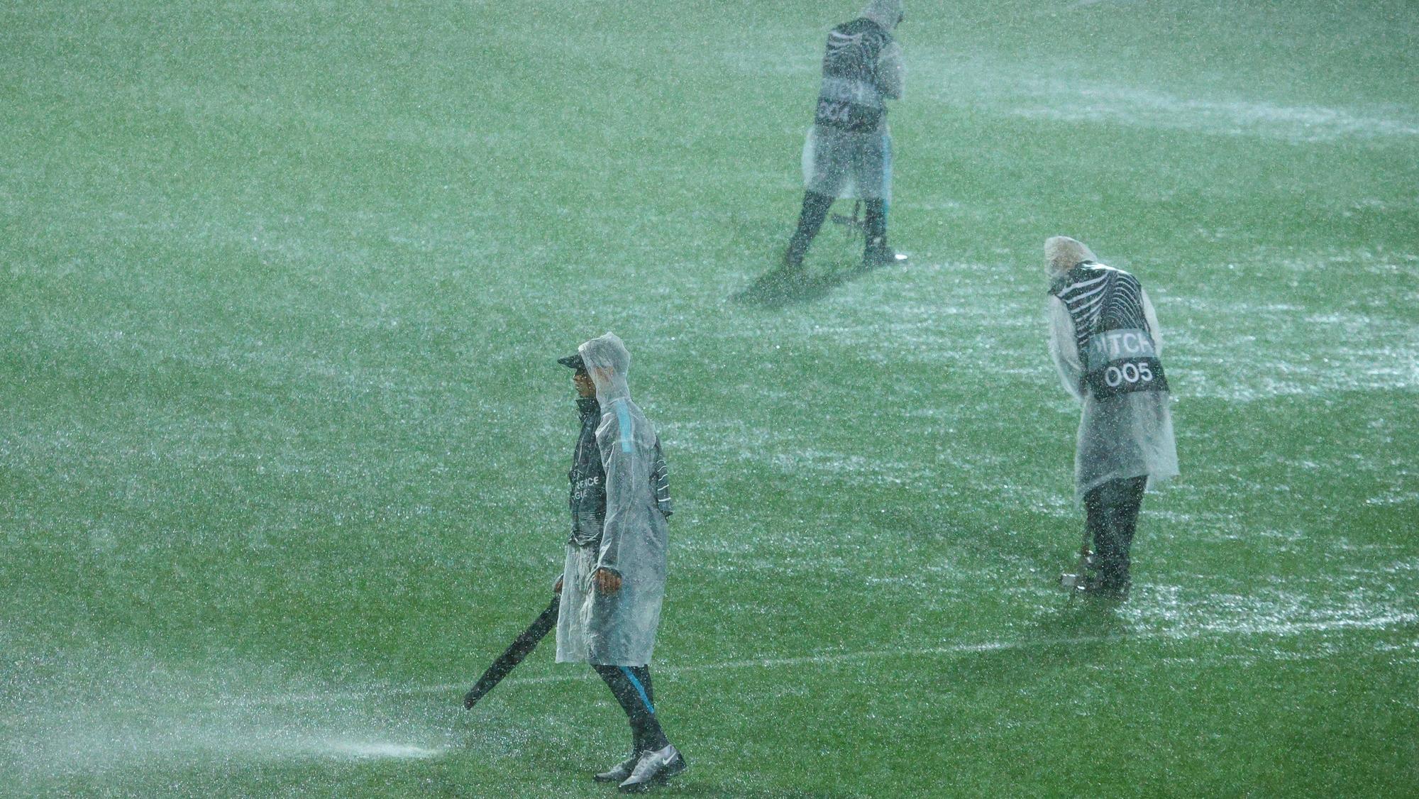 Helfer versuchen, den Rasen in Rijeka mit Laubbläsern vom Wasser zu befreien.