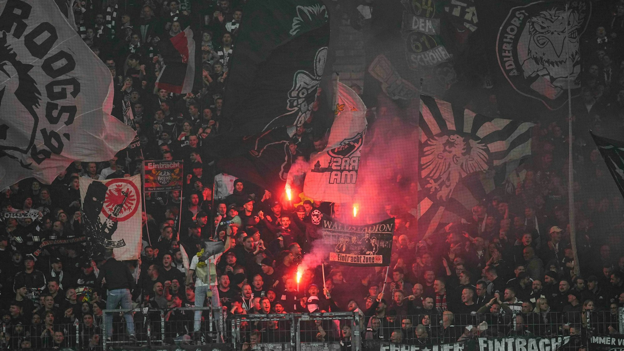 Fans von Eintracht Frankfurt zünden Pyrotechnik auf der Tribüne.