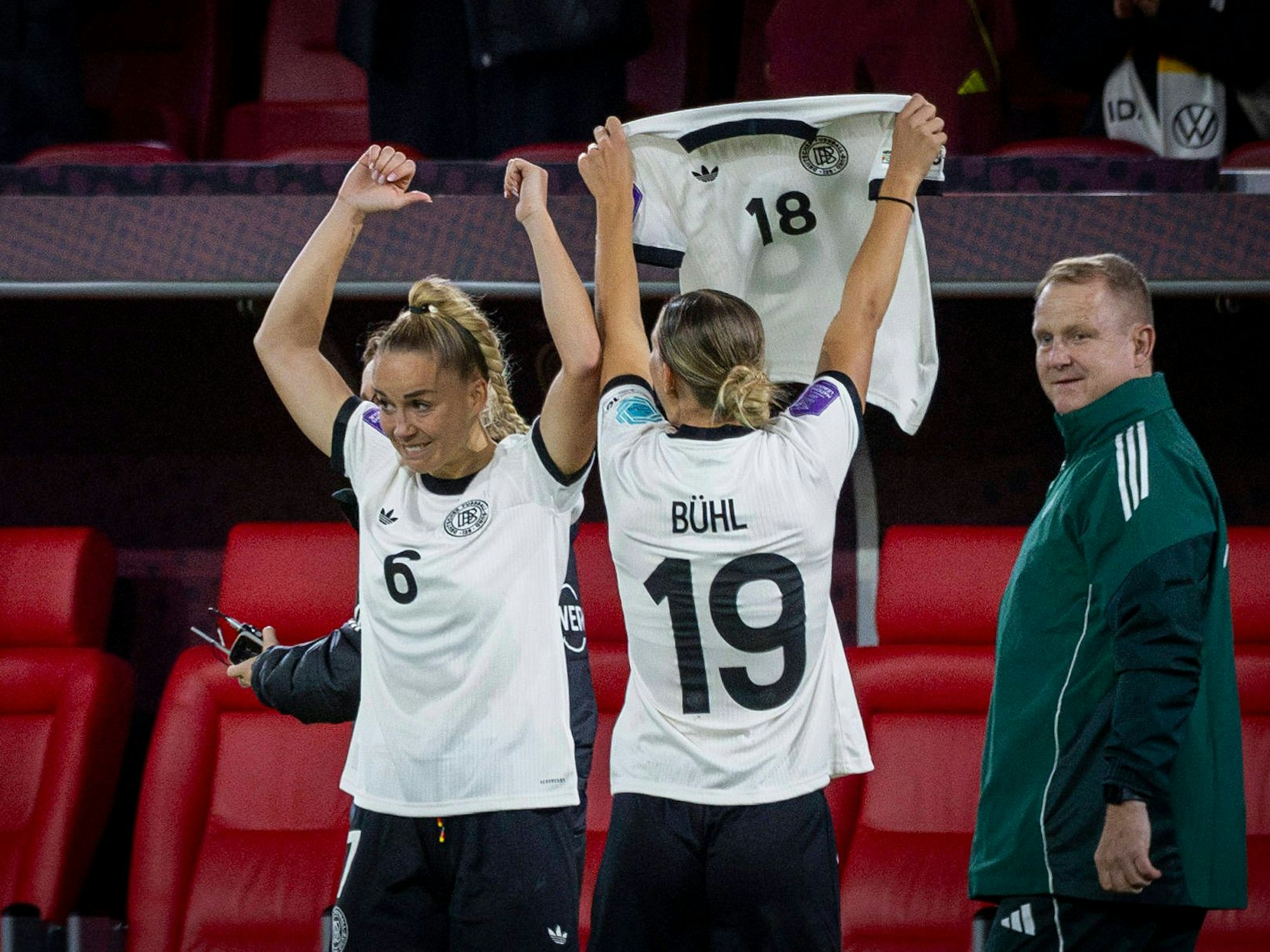 Giulia Gwinn trägt das Trikot von Lena Oberdorf, Klara Bühl hält das Trikot von Giovanna Hoffmann hoch.