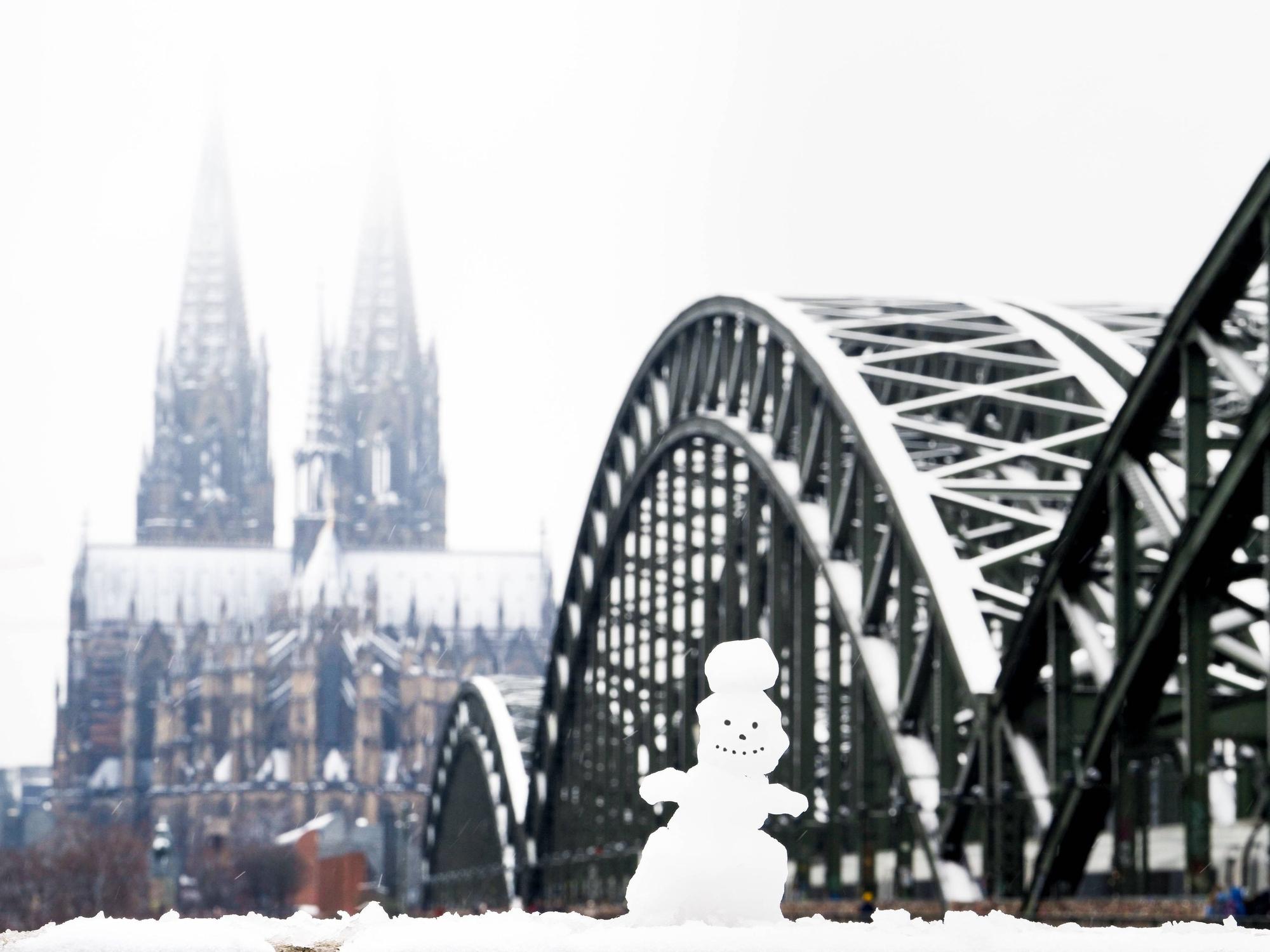 Ein Schneemann an der Rheinpromenade gegenüber dem Kölner Dom und der Hohenzollernbrücke.