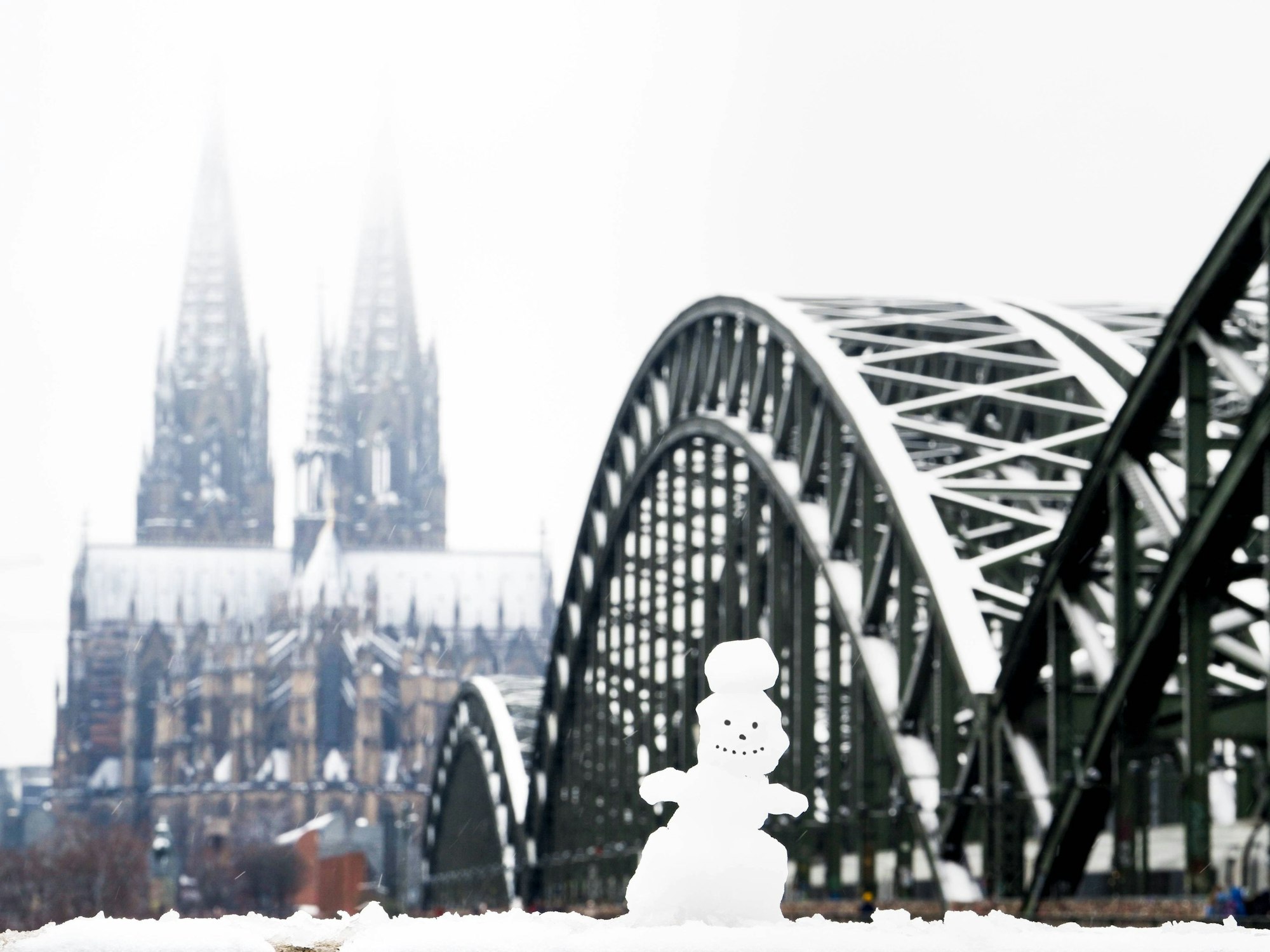Ein Schneemann an der Rheinpromenade gegenüber dem Kölner Dom und der Hohenzollernbrücke.