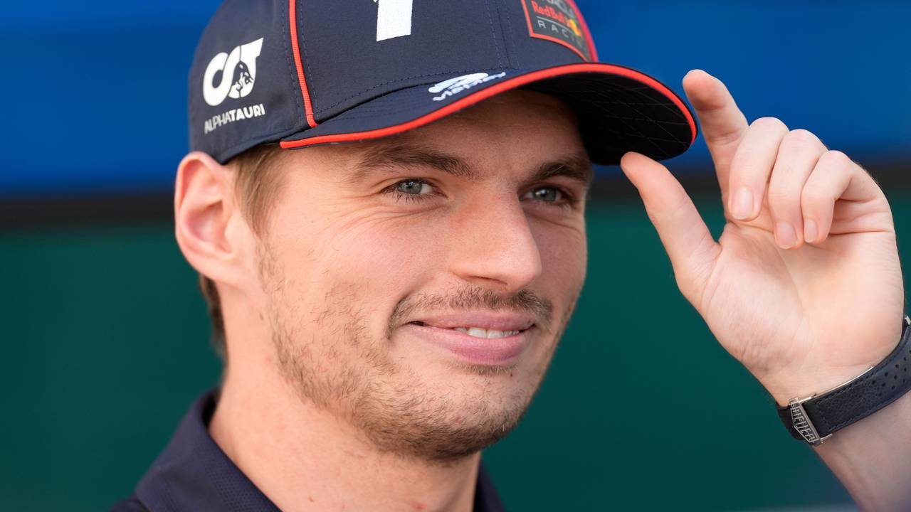 Max Verstappen fasst sich an die Kappe und lächelt.