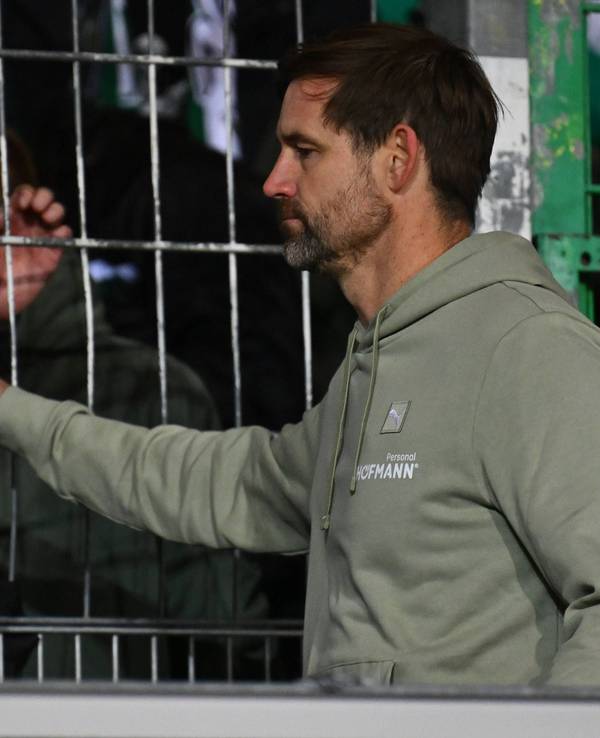 Thomas Kleine klatscht traurig mit Fans am Zaun ab.