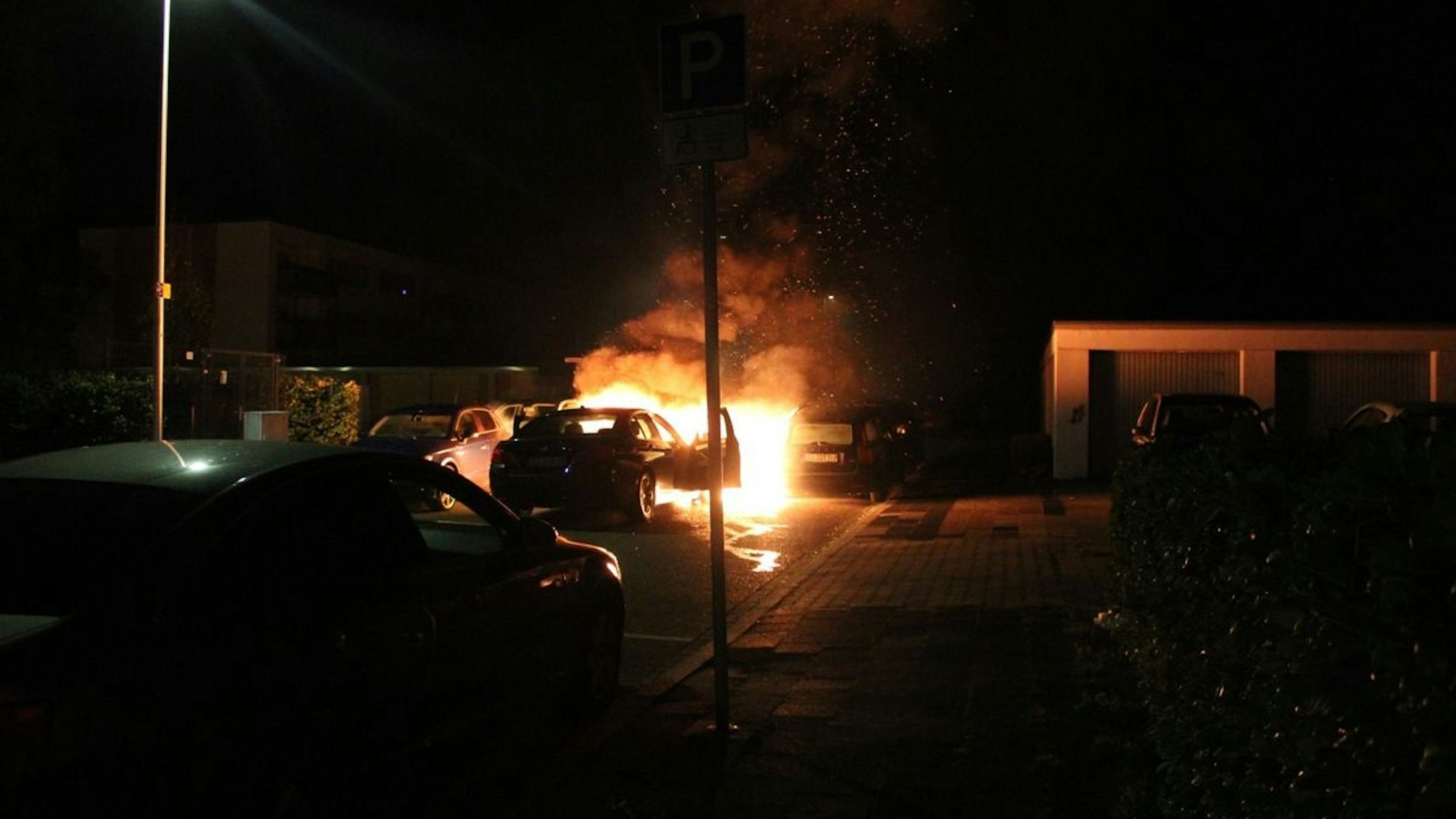 Ein ausgebranntes Auto steht auf einer Straße.