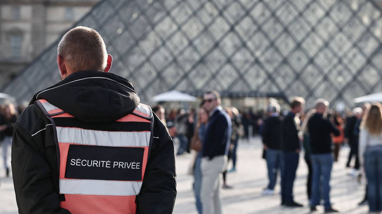 Nach einem Raub im Museum Louvre steht ein Sicherheitsmitarbeiter auf dem Platz vpr dem Eingang.