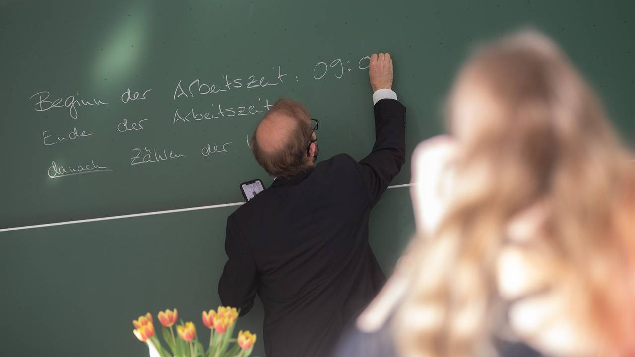 Ein Lehrer schreibt an der Singbergschule am ersten Tag der schriftlichen Abiturprüfungen 2022 in Hessen die Anfangszeit des Deutsch-Abiturs auf die Tafel.