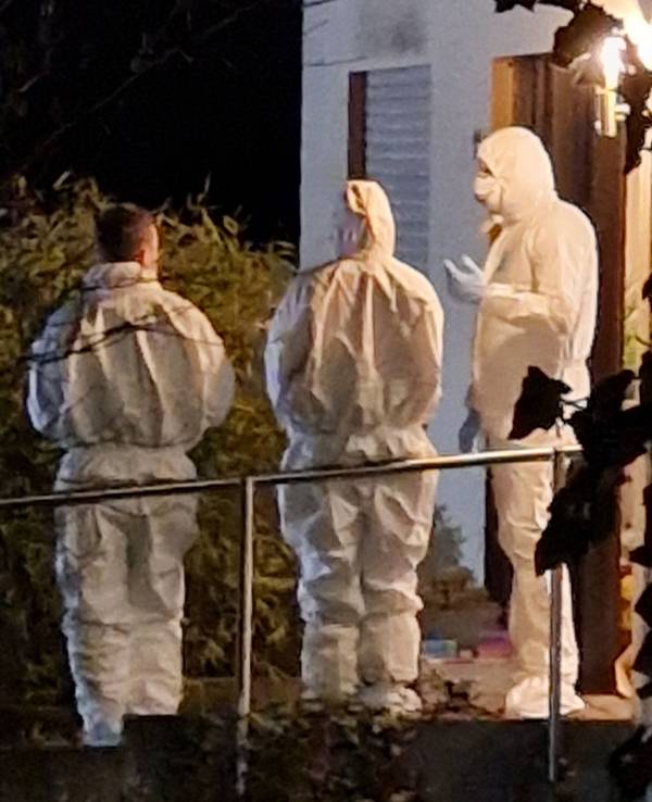 Ermittler stehen vor einem Wohnhaus in Solms, in dem drei tote Menschen entdeckt wurden. Bei den Toten handelt es sich um Vater, Mutter und Tochter.